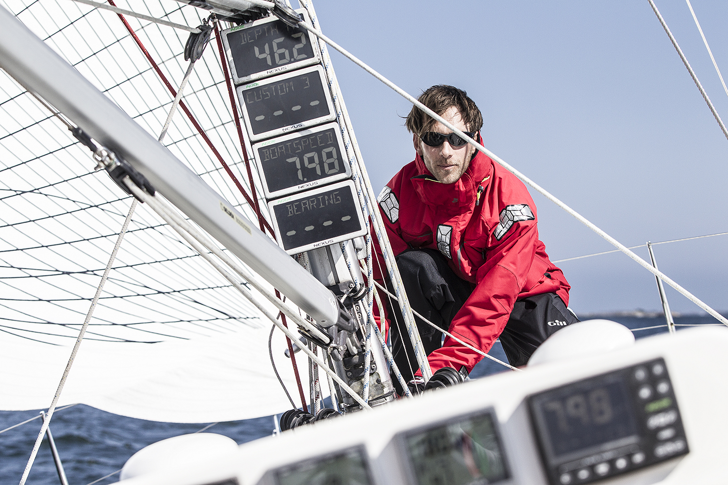 Man wearing a red Gill jacket on a racing boat